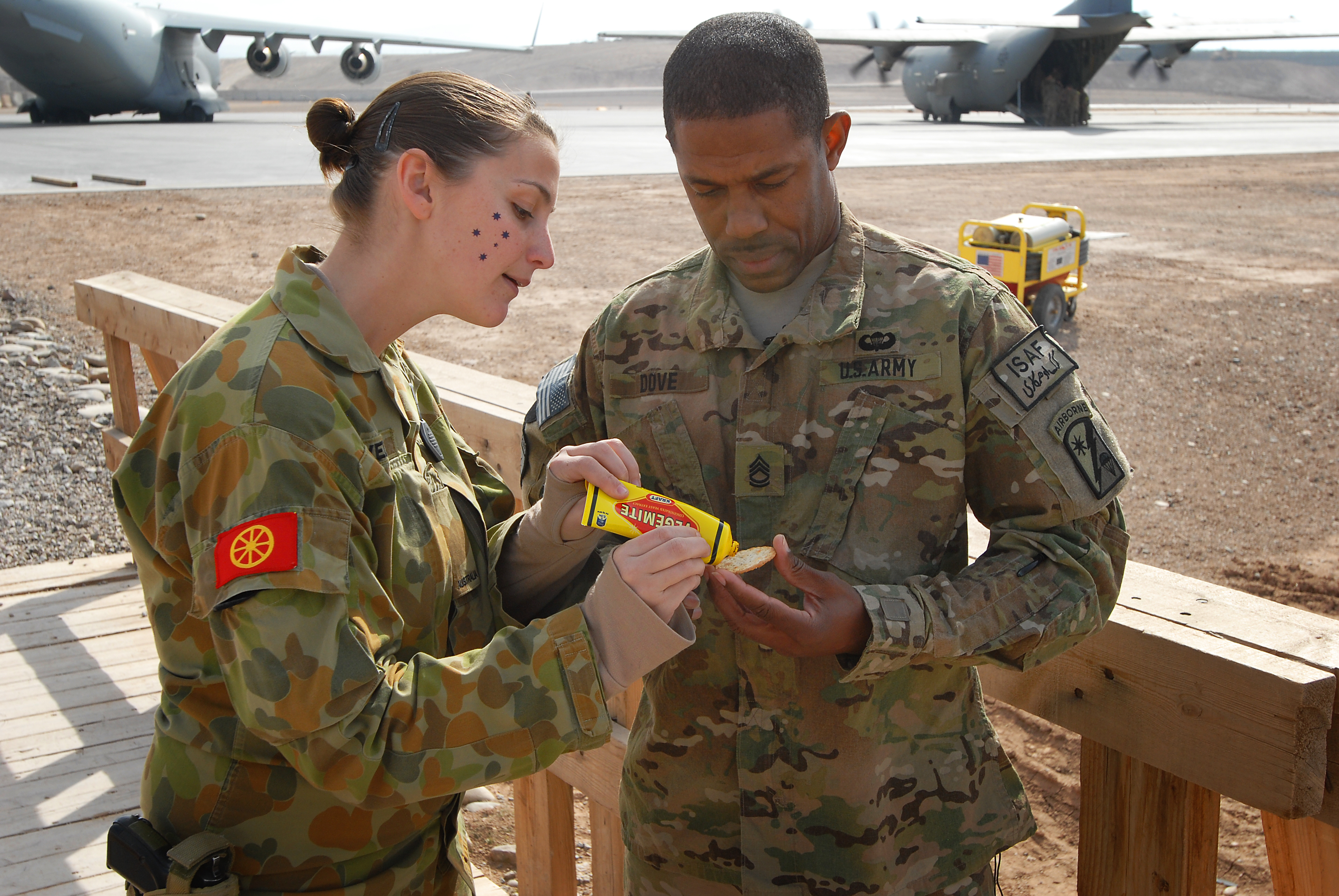 Australian Army Pvt. Tara Pavel explains the best way to eat Vegemite to Sgt. 1st Class Patrick Dove, 329th Transportation Detachment, 49th Joint Movement Control Battalion, at Multi National Base Tarin Kot, Afghanistan, on Australia Day, Jan. 26, 2013. Vegemite is an Australian food spread for sandwiches, toast, and biscuits, but for Americans is an acquired taste.